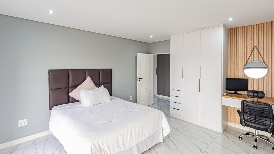 A furnished main bedroom with a plain double bed, before restyling