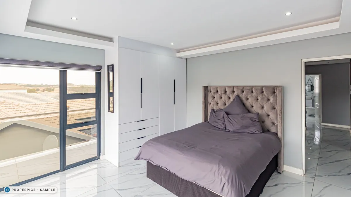 A bedroom as photographed from the corner by the sliding door, with its own furniture