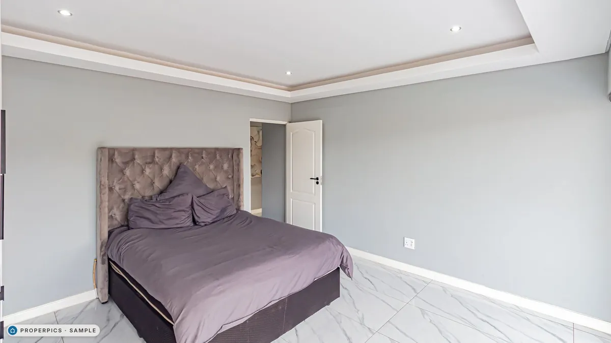A bedroom as photographed from the far side of the room, facing the bed, with its own furniture