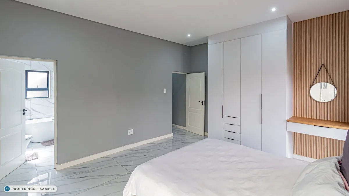 A bedroom as photographed from beside the bed, facing the en-suite, with its own furniture