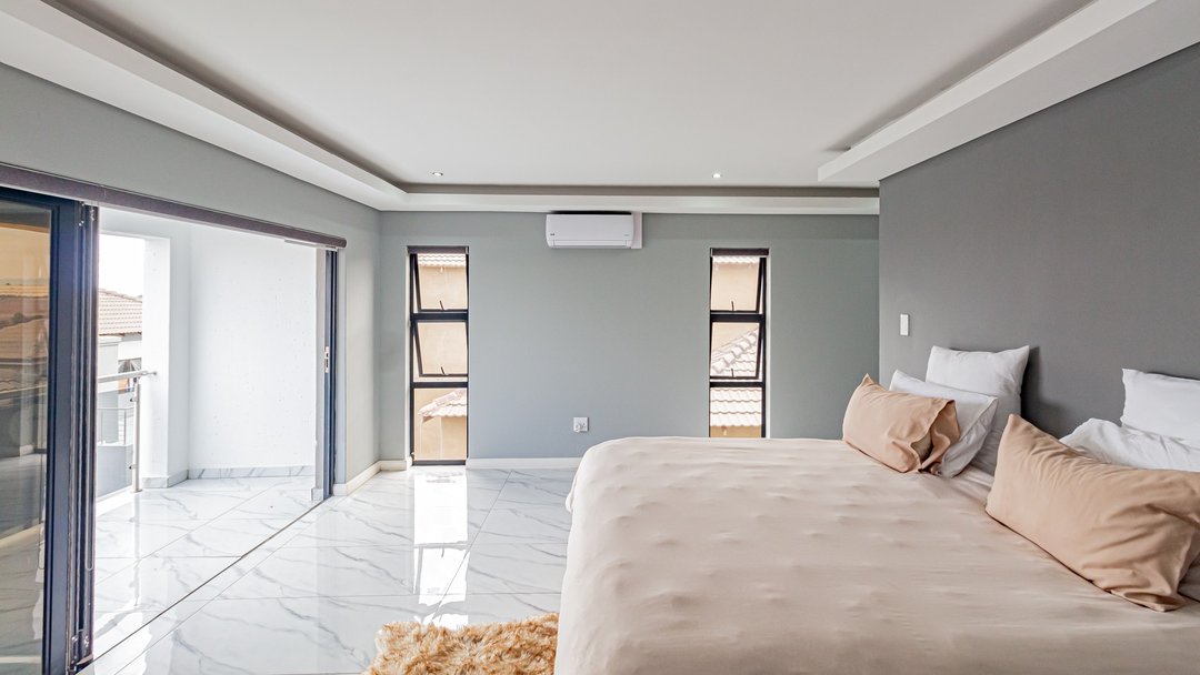A plain bed against bare walls, before restyling
