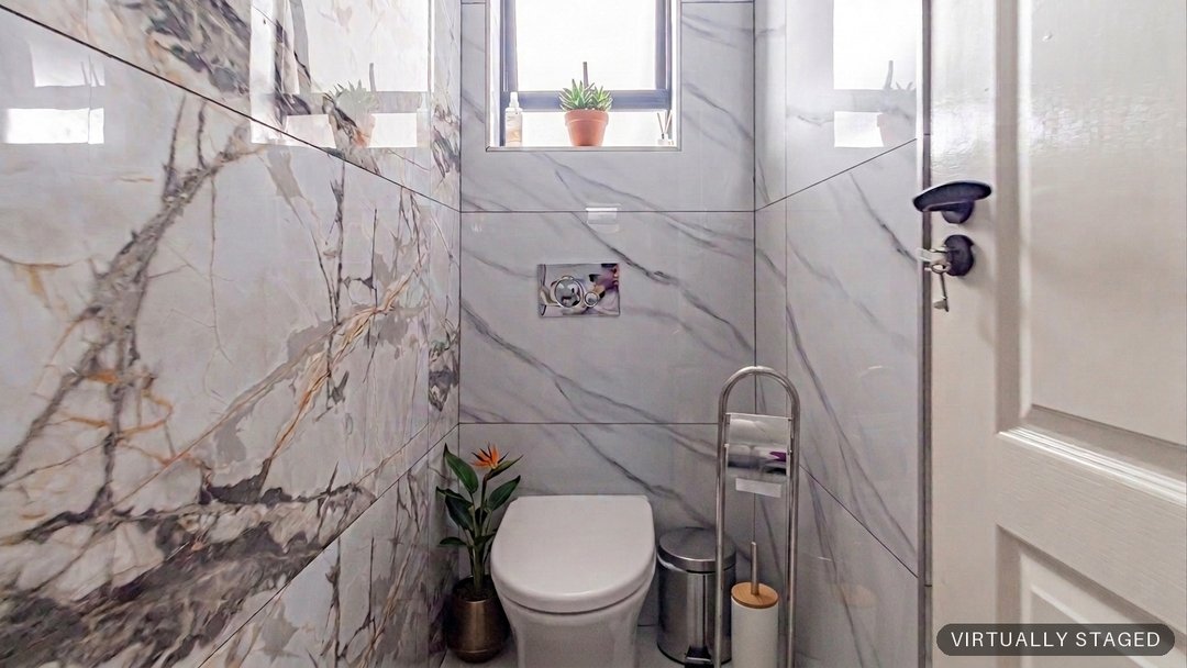 The same guest bathroom with towels, a plant and styling added by ProperPics