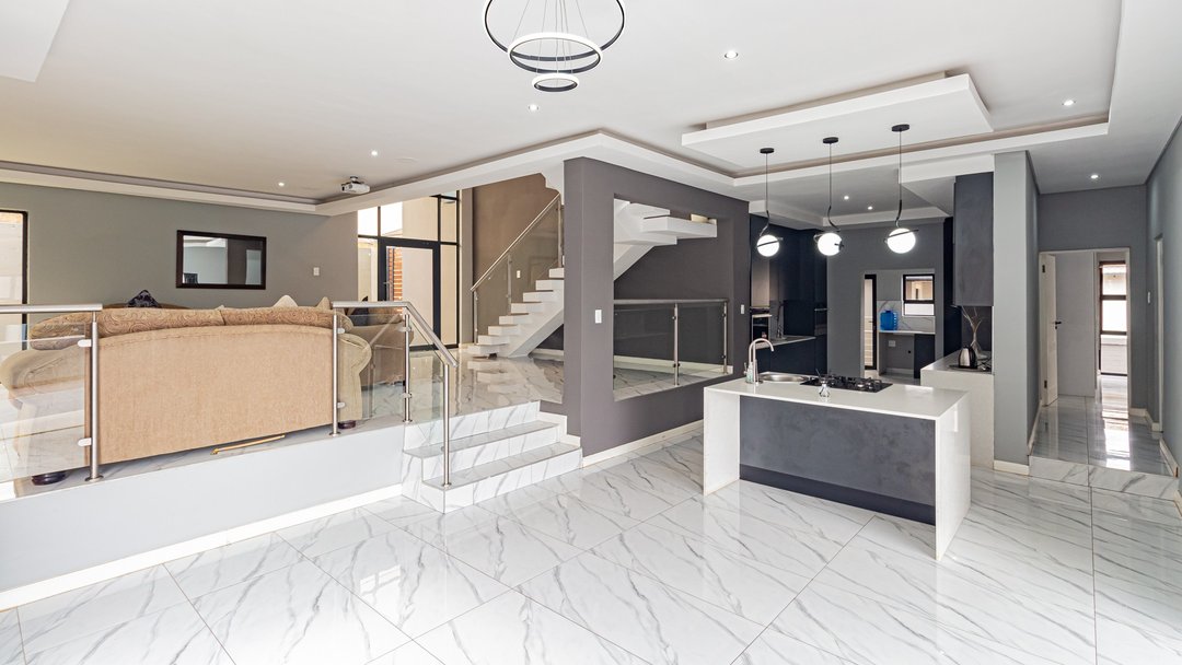 An empty open-plan dining area beside the kitchen island, before staging