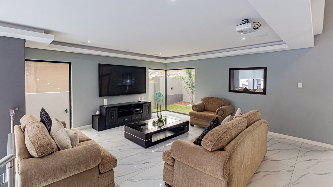 An open-plan living area with dated couches, before restyling