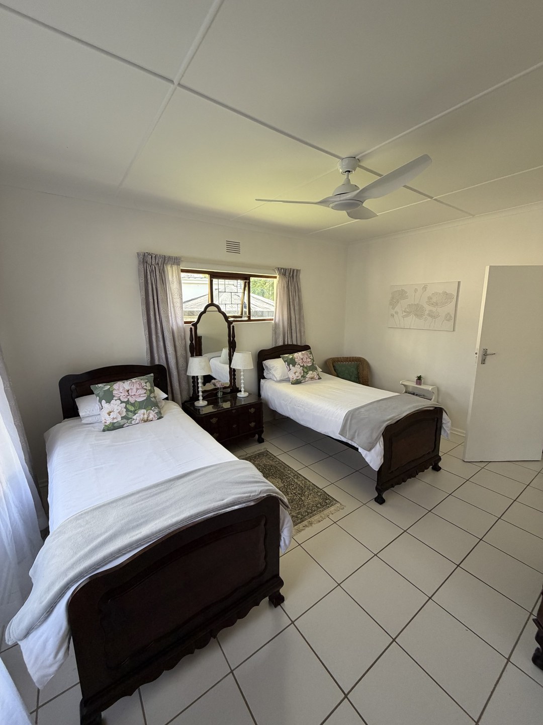 A furnished bedroom with dated twin beds, before restyling
