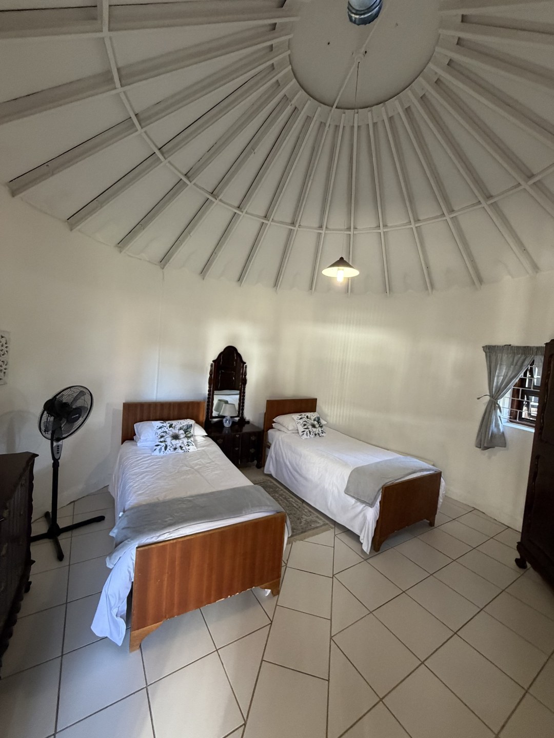 A bedroom with dated furniture under a domed ceiling, before restyling