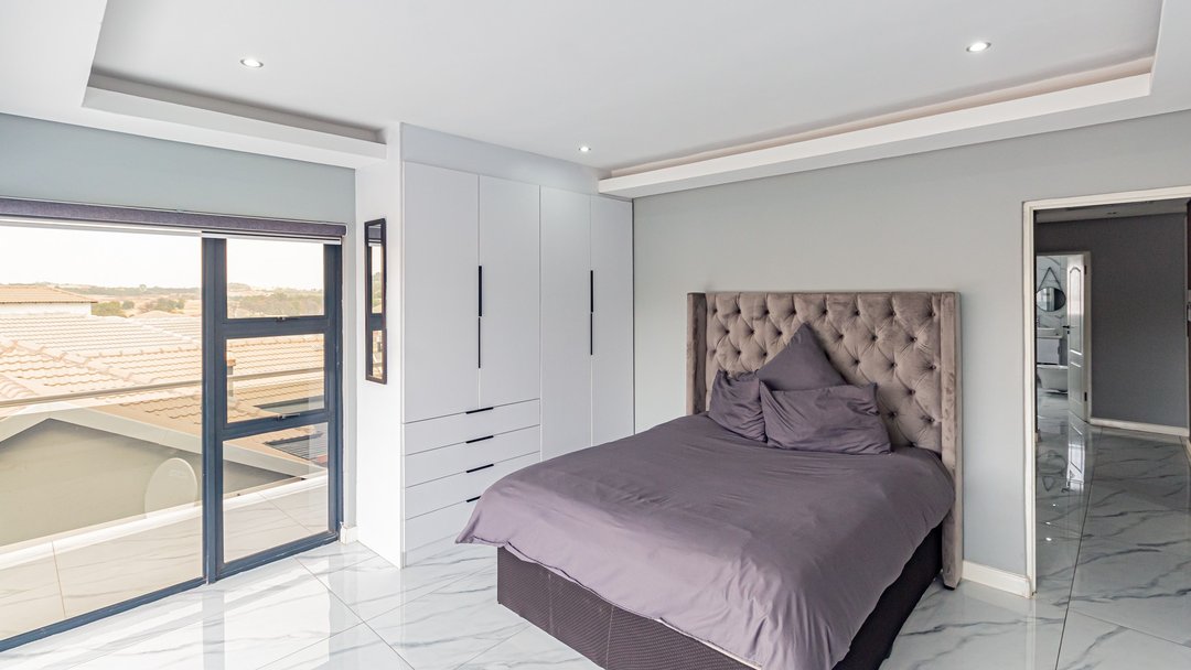 A bedroom with built-in wardrobes and bare walls, before staging